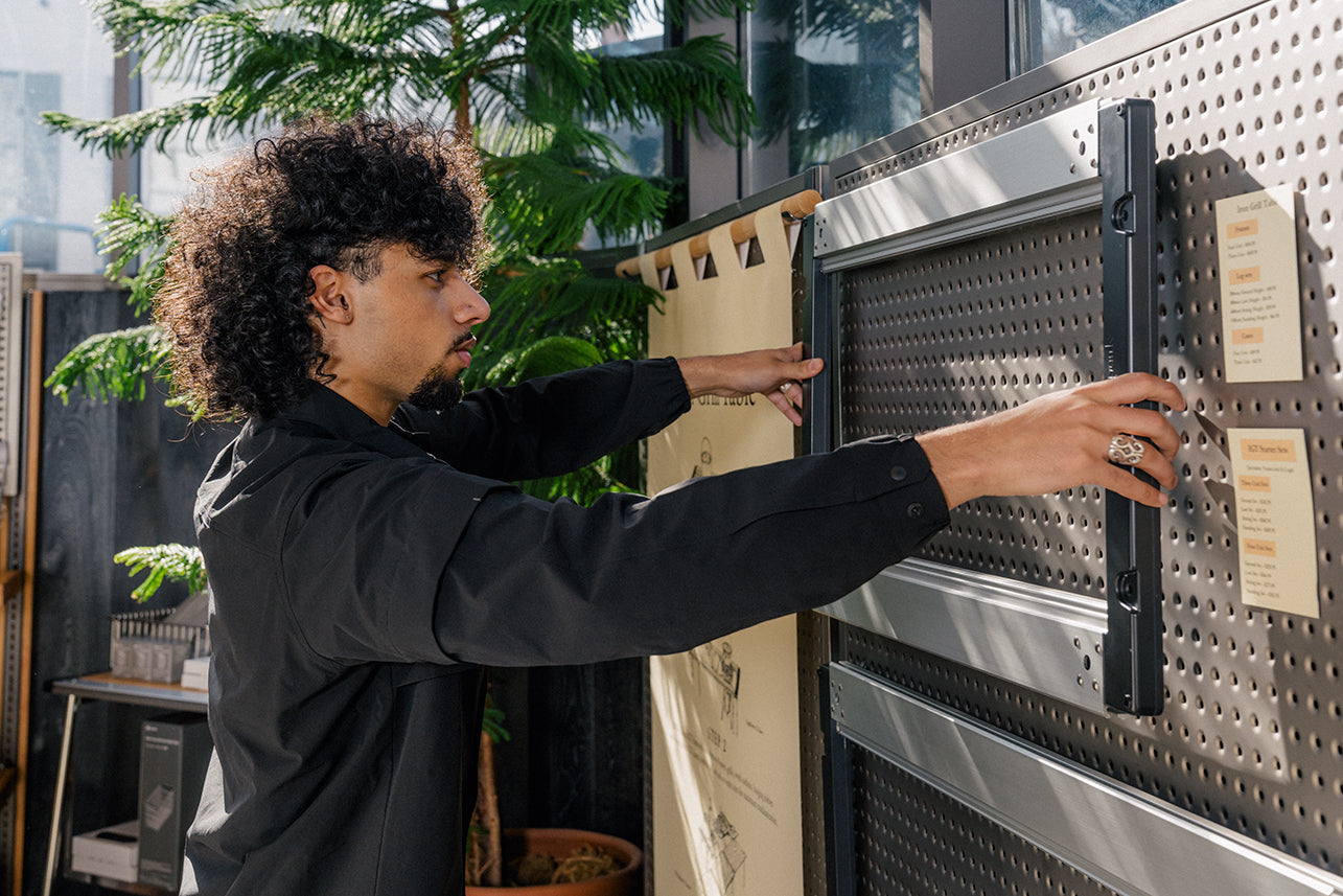 A retail associate in Portland, Oregon wearing a snow peak shirt and showcasing outdoor cooking equipment