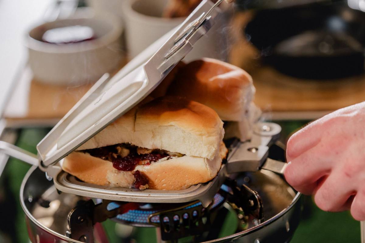 man cooking sandwiches on grill