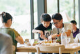 A family eats at a table at one of the Snow Peak Eats locations in Japan.