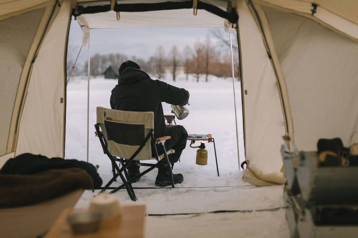 man cooking outdoors with snow peak stove