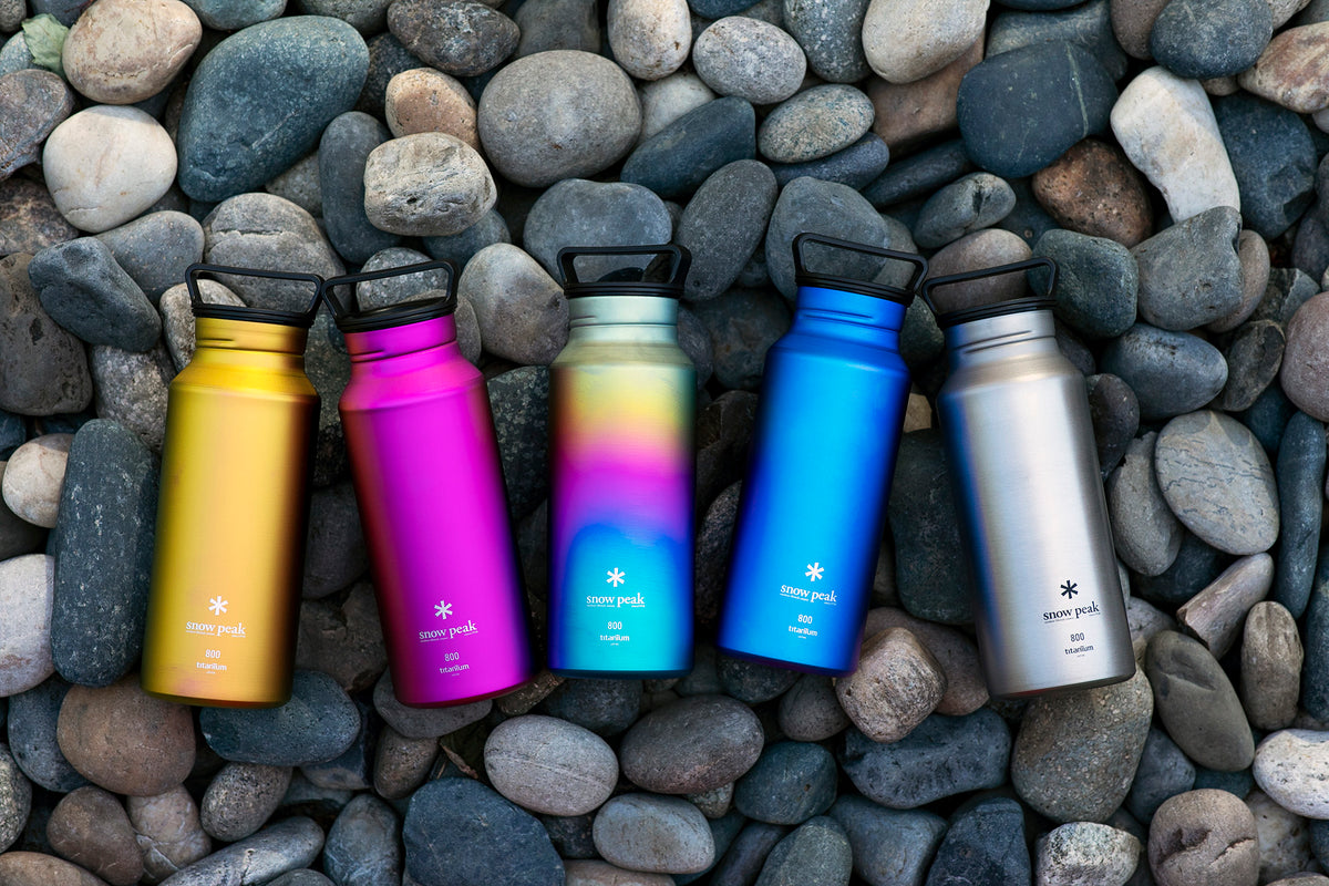 Snow Peak titanium bottles on river rocks